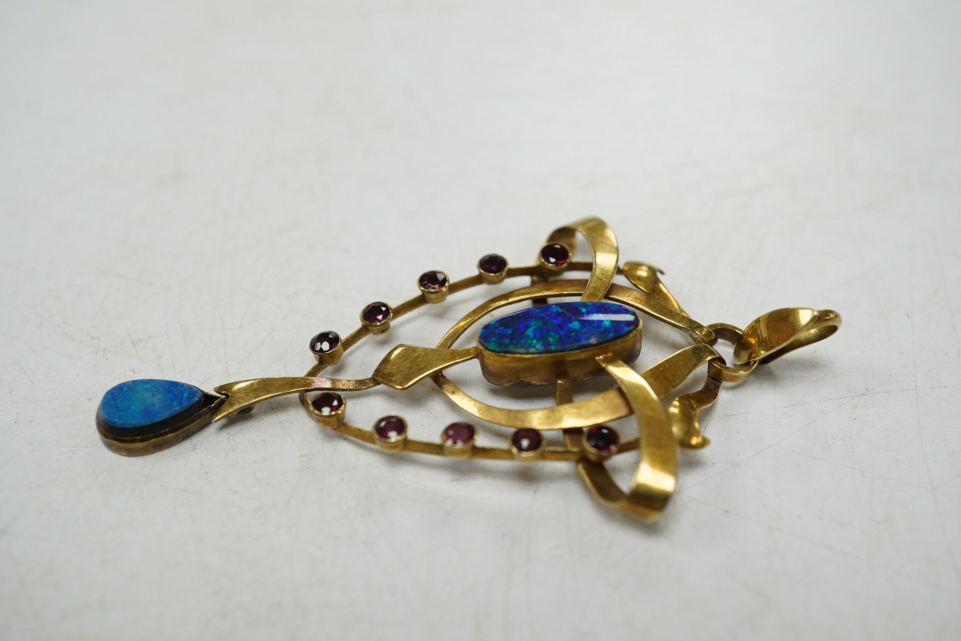 An Edwardian Art Nouveau 15ct, black opal doublet and ruby cluster set drop pendant, 55mm, gross weight 3.9 grams. Condition - fair to good